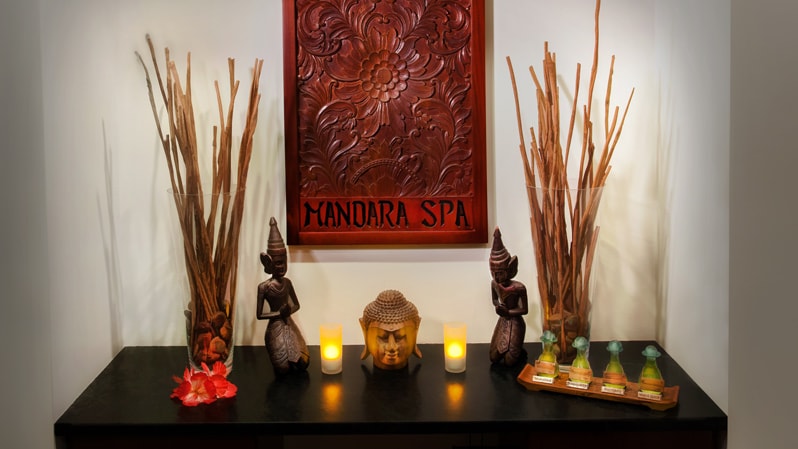 A table decorated with candles and Asian-influenced figurines