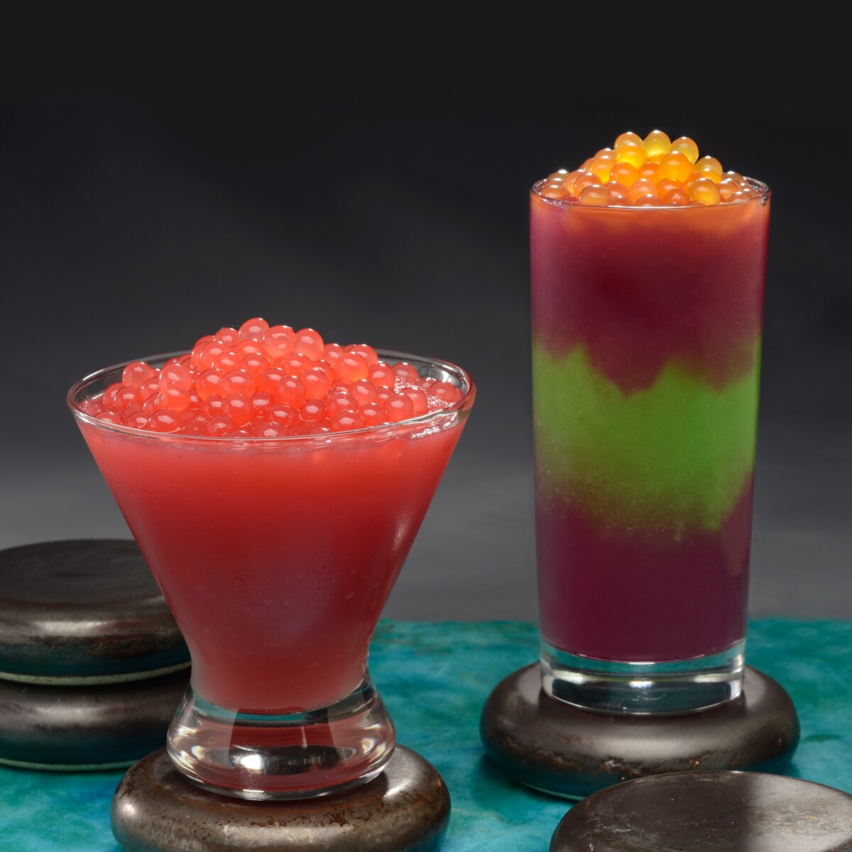 Two frozen beverages topped with boba balls